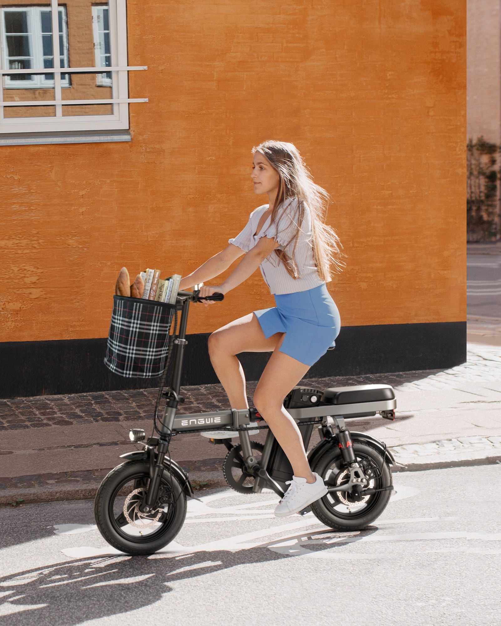 ENGWE T14 urban e-bike with 250W motor, rider carrying groceries in a stylish basket on city street.